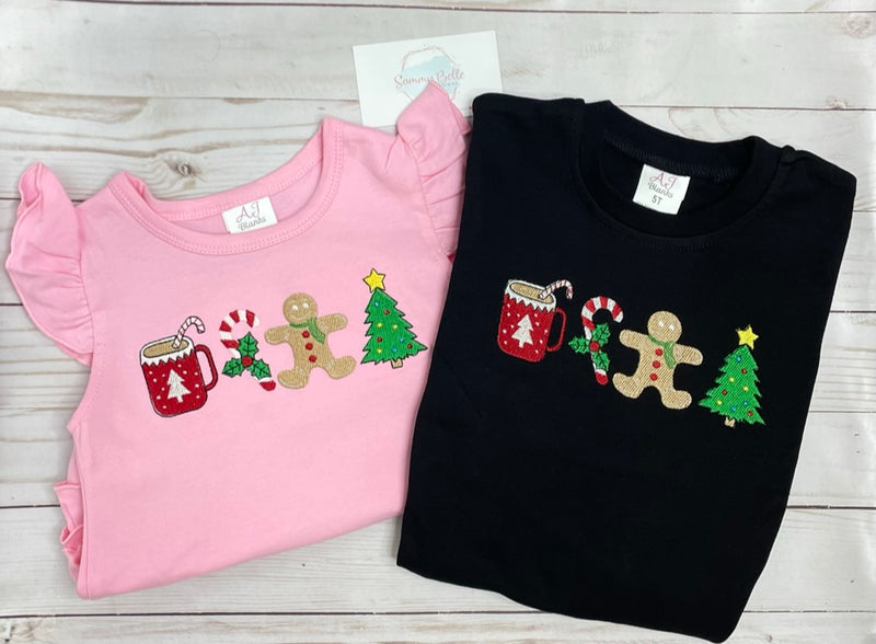Pink and black shirts with Christmas-themed designs on a wooden surface