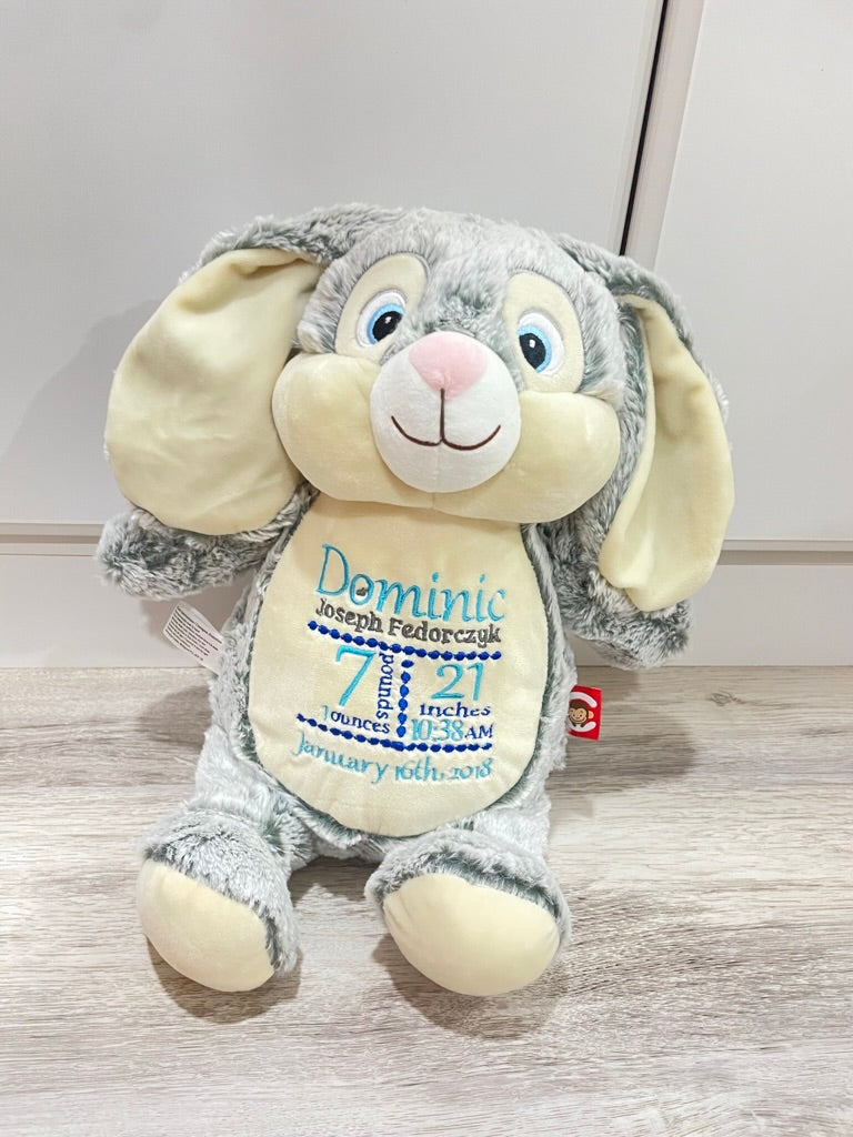 Plush bunny toy with personalized text on a wooden floor