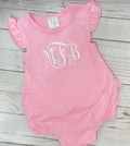 Pink baby romper with ruffled sleeves and 'MFB' monogram on a wooden surface